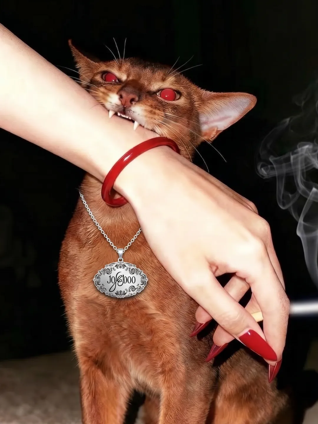 Social post: a red eyed cat biting a wrist wearing a red bangle, a silver lace seal pendant with the wordmark around its neck